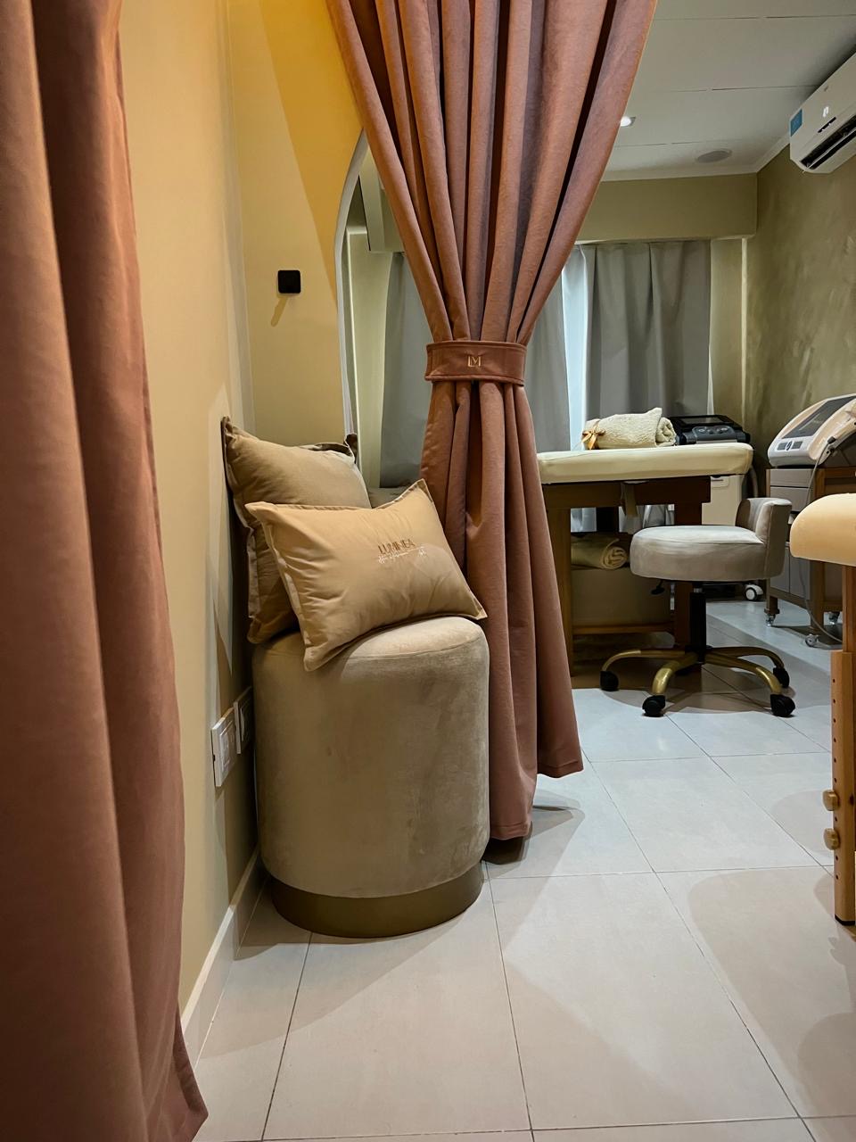 Rincón de bienestar de LUMINEA ESTETICA con almohadones y cortinas